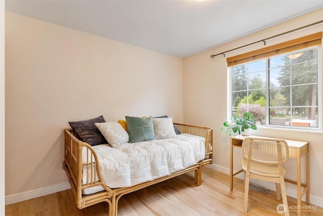 living area with baseboards and wood finished floors