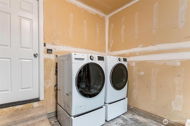 clothes washing area featuring laundry area and washer and clothes dryer