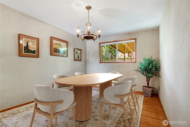 dining room with light wood finished floors and a notable chandelier