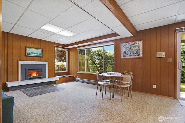 dining room featuring plenty of natural light, a glass covered fireplace, and carpet floors