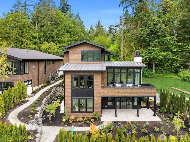 4815 Rosalind Rd NE, Bainbridge Island, WA 98110 - back of house featuring a standing seam roof, a patio area, metal roof, and a chimney