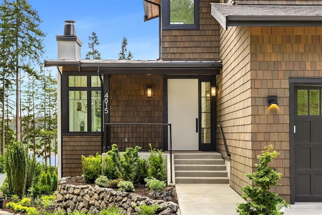 4815 Rosalind Rd NE, Bainbridge Island, WA 98110 - view of exterior entry featuring a chimney and a shingled roof