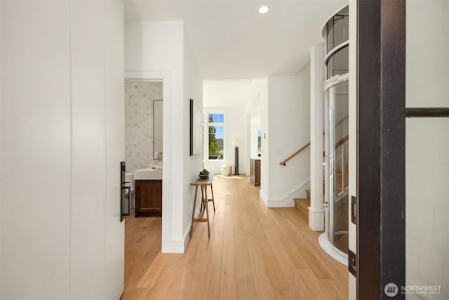 4815 Rosalind Rd NE, Bainbridge Island, WA 98110 - hall with light wood-style flooring, stairway, baseboards, and a sink
