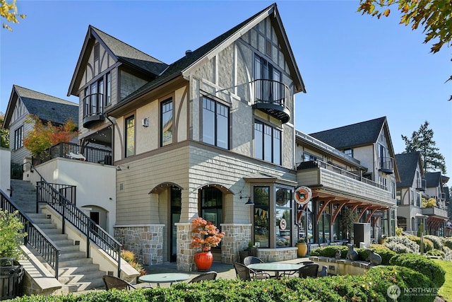 4815 Rosalind Rd NE, Bainbridge Island, WA 98110 - exterior space with a balcony, stone siding, stairs, and stucco siding