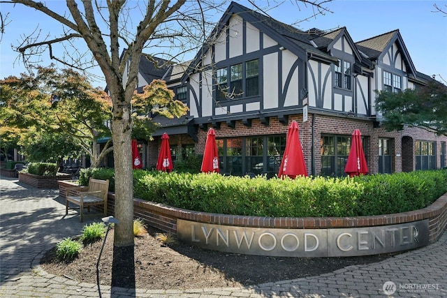 4815 Rosalind Rd NE, Bainbridge Island, WA 98110 - view of property exterior featuring brick siding, stucco siding, and roof with shingles