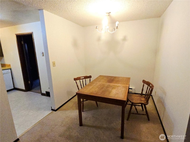 dining room with an inviting chandelier, baseboards, a textured ceiling, and light colored carpet