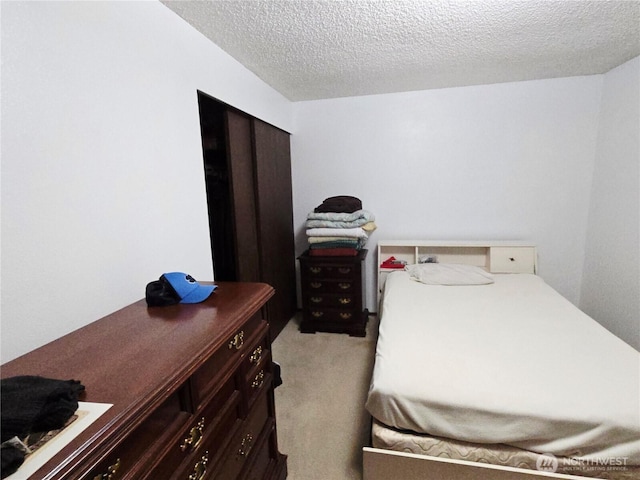 bedroom featuring light colored carpet and a textured ceiling