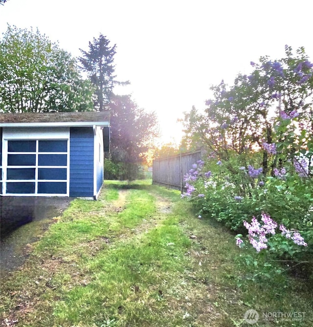 view of yard with fence, an outdoor structure, and a shed