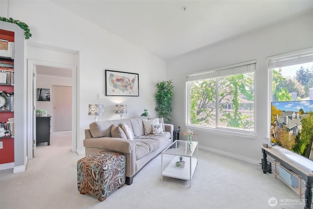 living room featuring carpet floors, baseboards, and lofted ceiling
