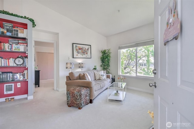 living area featuring carpet floors, baseboards, and lofted ceiling