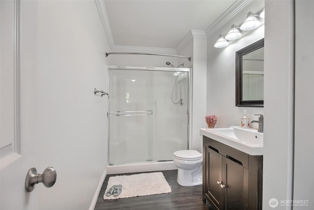 full bathroom featuring crown molding, vanity, a stall shower, and wood finished floors
