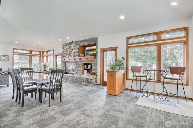 dining space with plenty of natural light, recessed lighting, and a stone fireplace