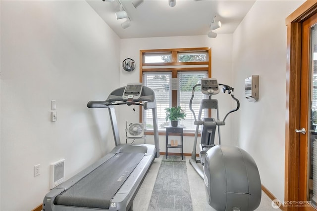 exercise room featuring track lighting, carpet flooring, baseboards, and visible vents