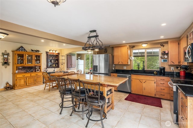 28405 59th Ave NE, Arlington, WA 98223 - kitchen featuring recessed lighting, light tile patterned floors, a sink, arched walkways, and appliances with stainless steel finishes