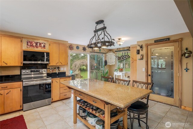 28405 59th Ave NE, Arlington, WA 98223 - kitchen featuring recessed lighting, light tile patterned flooring, a kitchen breakfast bar, dark countertops, and appliances with stainless steel finishes