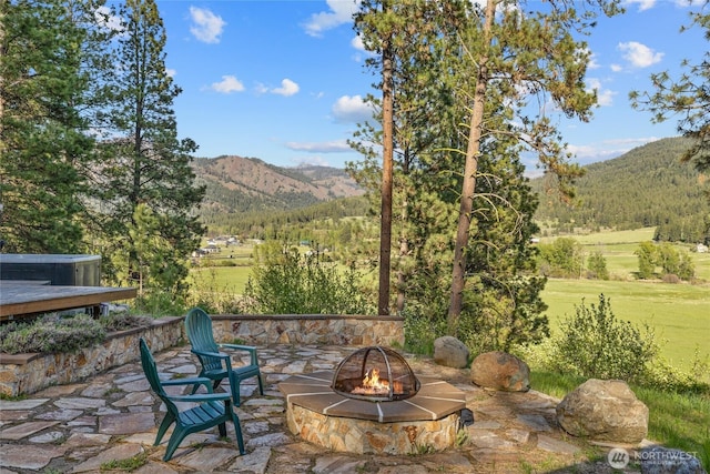 view of patio / terrace with a fire pit and a mountain view