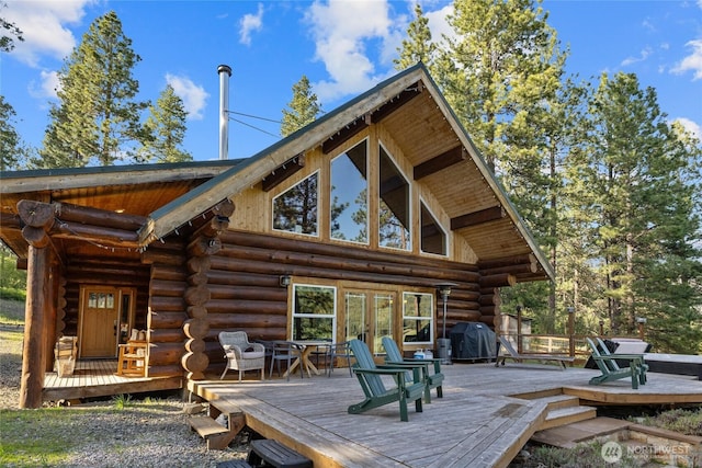 back of house with log siding, french doors, and a wooden deck