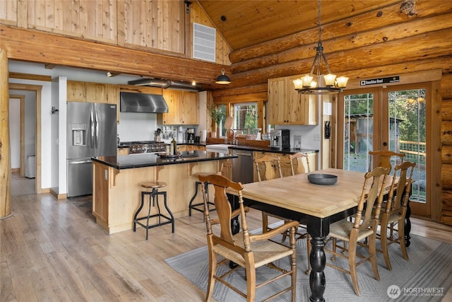 dining room featuring rustic walls, high vaulted ceiling, light wood-type flooring, healthy amount of natural light, and a chandelier