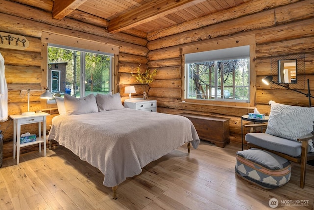bedroom with wooden ceiling, beamed ceiling, multiple windows, hardwood / wood-style floors, and rustic walls