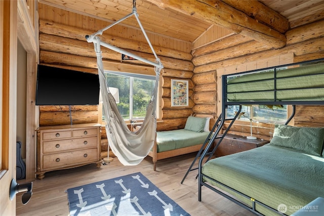 bedroom featuring log walls, wood ceiling, wood finished floors, and beam ceiling