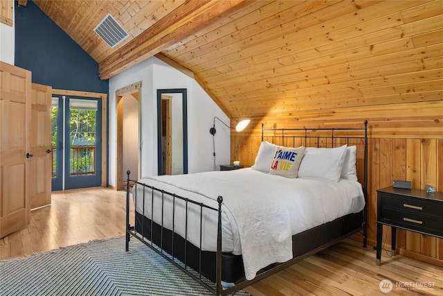 bedroom featuring vaulted ceiling, access to outside, wood finished floors, wood ceiling, and wooden walls