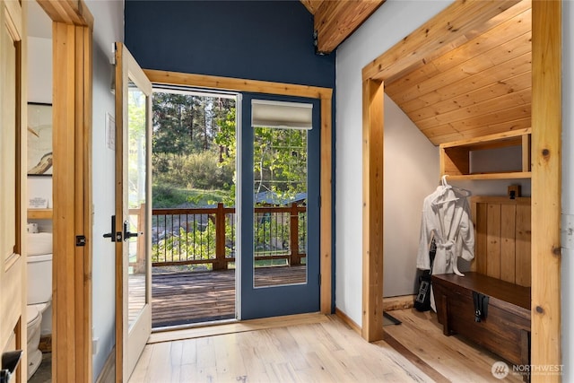 entryway with vaulted ceiling, wood finished floors, and baseboards