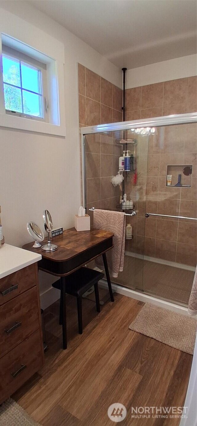bathroom featuring a shower stall and wood finished floors