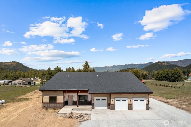 exterior space featuring a garage, a mountain view, and concrete driveway
