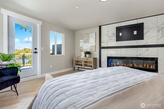 5732 Halls Lake Way, Lynnwood, WA 98036 - bedroom featuring access to outside, baseboards, wood finished floors, and a tiled fireplace