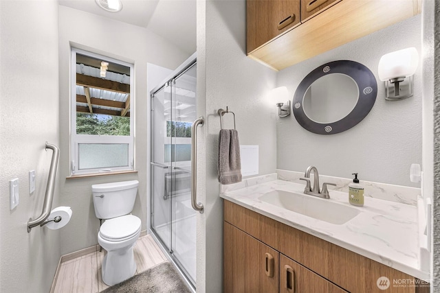 full bath with toilet, baseboards, a shower stall, and vanity