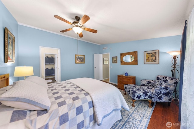 bedroom featuring ornamental molding, a ceiling fan, and wood finished floors