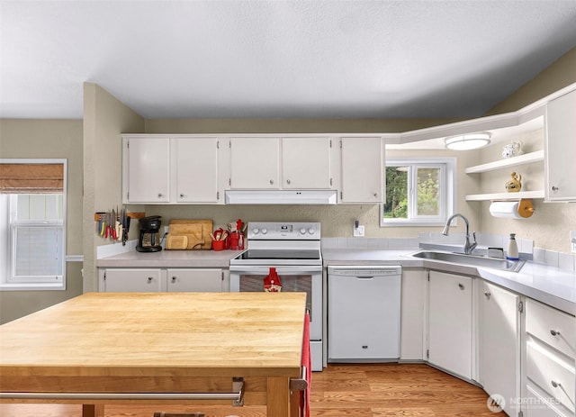 kitchen featuring a sink, white appliances, light countertops, white cabinetry, and under cabinet range hood