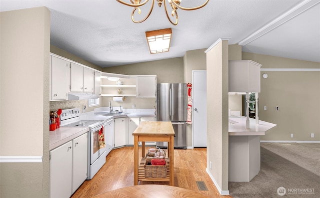 kitchen with open shelves, freestanding refrigerator, light countertops, electric stove, and vaulted ceiling