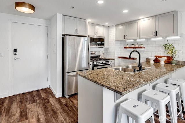 1420 Terry Ave Unit 603, Seattle, WA 98101 - kitchen with stainless steel appliances, a sink, a peninsula, a breakfast bar, and backsplash