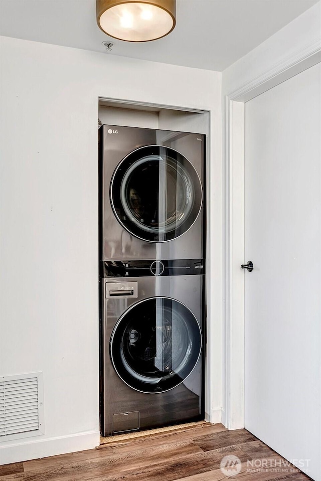 1420 Terry Ave Unit 603, Seattle, WA 98101 - washroom with stacked washer / dryer and wood finished floors