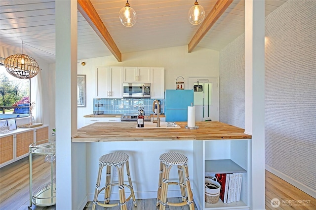 1892 Cascade View Dr, Camano Island, WA 98282 - kitchen featuring decorative backsplash, light wood-style floors, lofted ceiling with beams, a sink, and stainless steel appliances
