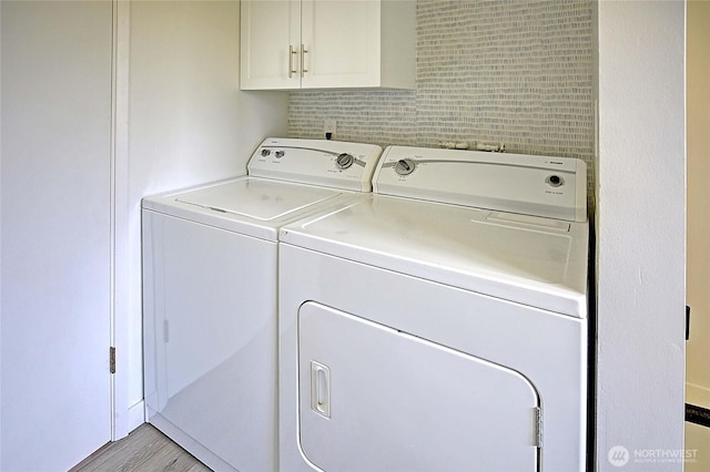 1892 Cascade View Dr, Camano Island, WA 98282 - clothes washing area featuring cabinet space, wood finished floors, and washing machine and clothes dryer