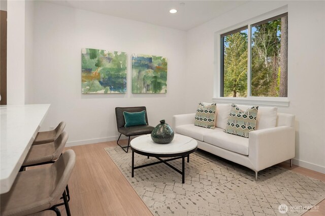 living room with baseboards, recessed lighting, and light wood-style flooring