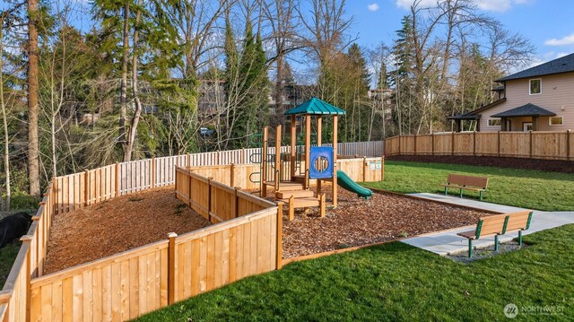 view of playground with a lawn and fence