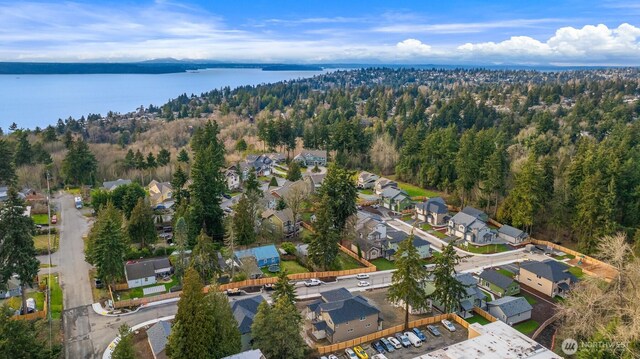 bird's eye view with a water view, a residential view, and a wooded view