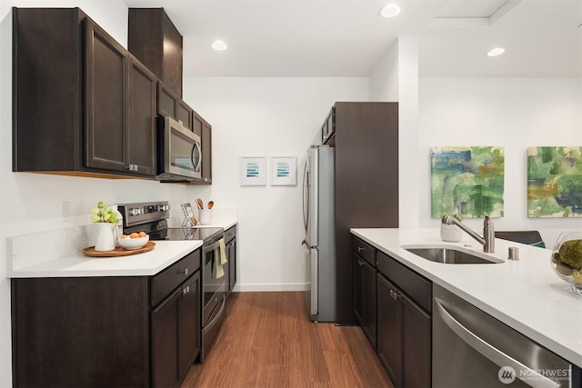 1240 SW 124th St Unit 10B, Burien, WA 98146 - kitchen featuring a sink, dark brown cabinetry, dark wood-style flooring, light countertops, and appliances with stainless steel finishes