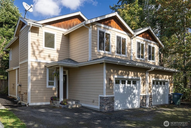 craftsman house featuring board and batten siding, an attached garage, and driveway