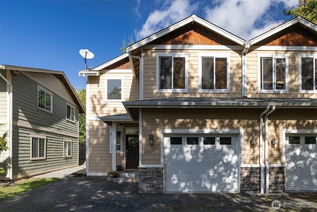 craftsman inspired home featuring driveway, stone siding, and a garage