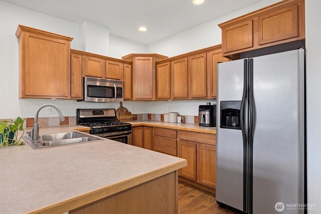 kitchen with a sink, light countertops, stainless steel appliances, and recessed lighting