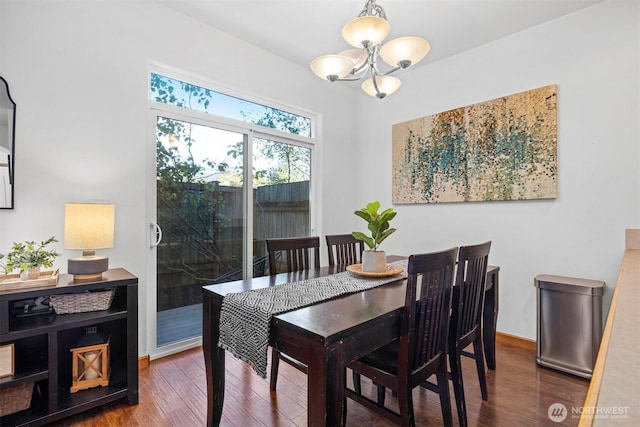 dining area with an inviting chandelier, baseboards, and wood finished floors