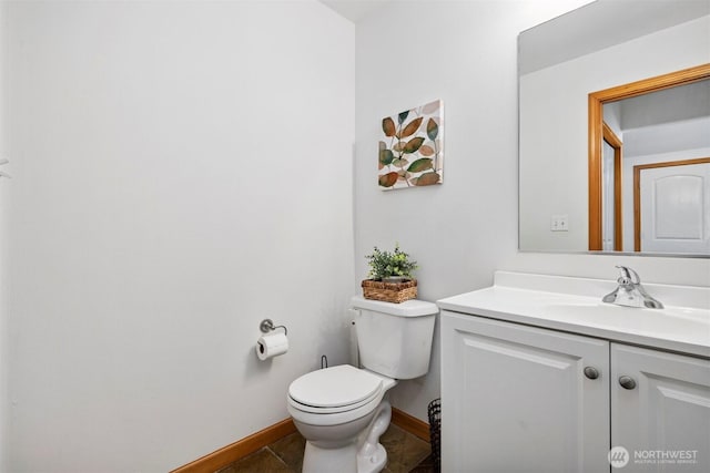 half bathroom featuring vanity, baseboards, and toilet