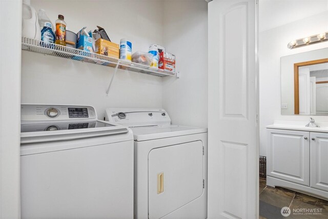 clothes washing area featuring washer and dryer, laundry area, and a sink