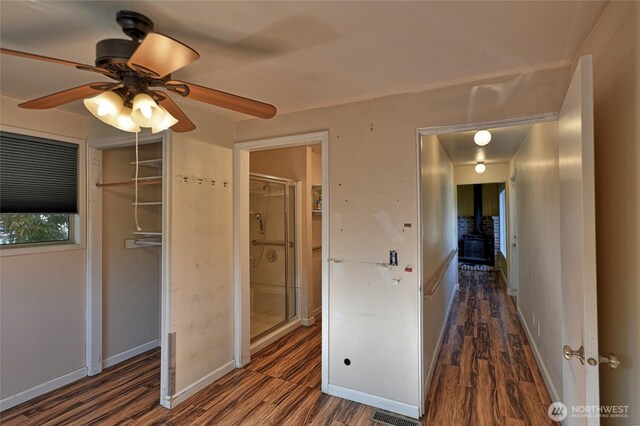 unfurnished bedroom featuring wood finished floors, baseboards, a ceiling fan, and a closet