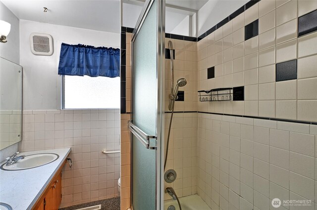 full bath featuring double vanity, shower / bath combination with glass door, and toilet