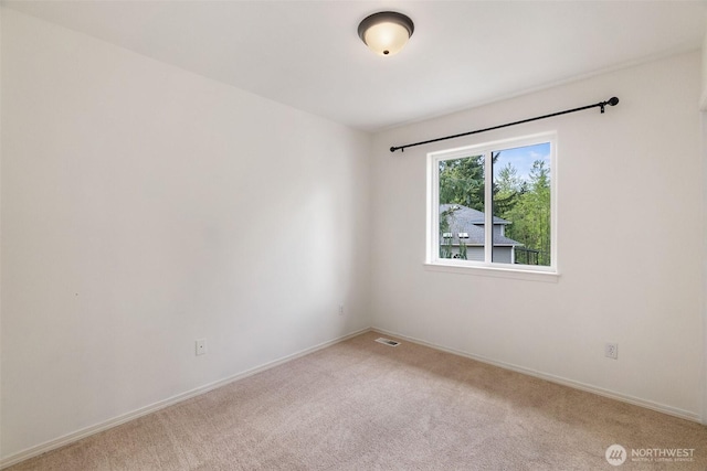unfurnished room featuring baseboards, visible vents, and light carpet